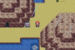 The player standing beside a sign between rocky cliffs and a small pool of water.