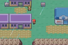 The player walking through a dim town near a Poke Mart and houses.